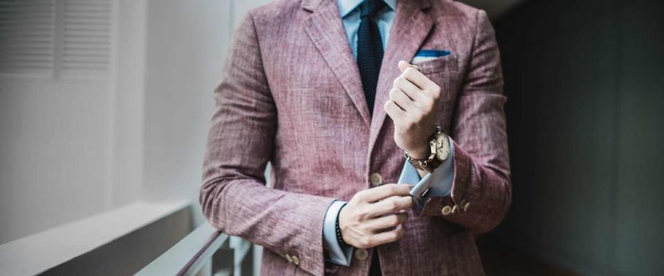 well-dressed young man fixing his sleeves on his suit