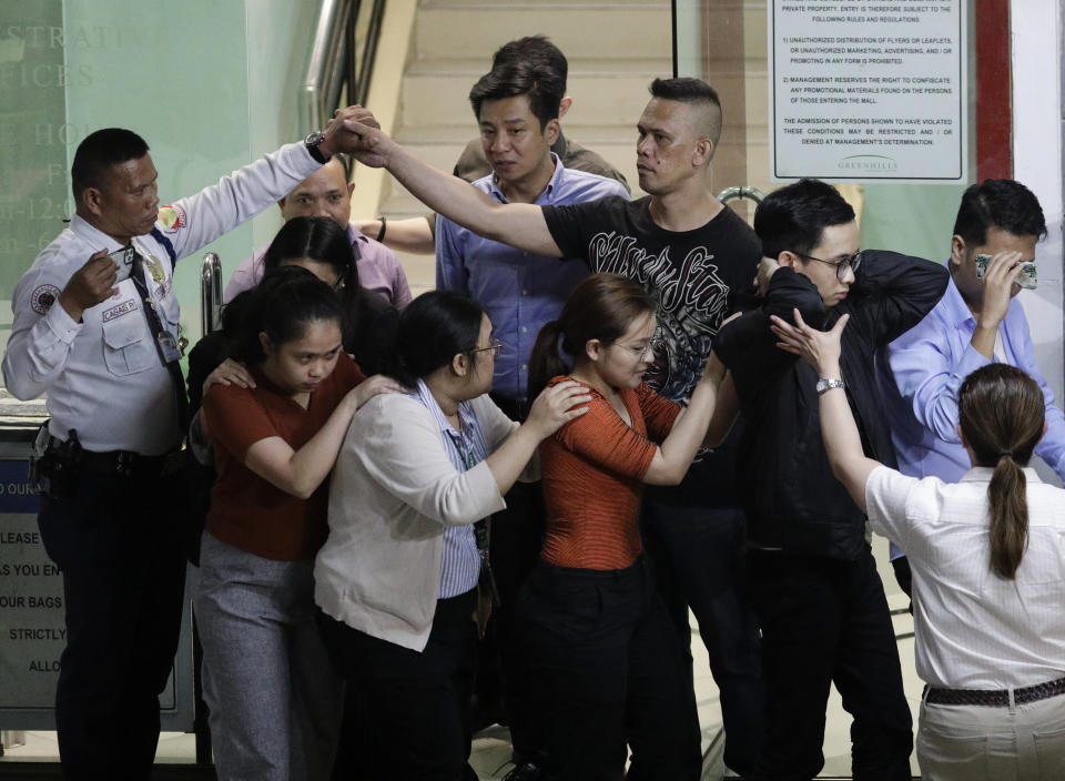 CAPTION CORRECTION CORRECTS FIRST NAME: Hostage taker Alchie Paray, right, shakes hands with a security guard in uniform as he after releases all his hostages at the VV-Mall in Manila, Philippines on Monday, March 2, 2020. Officials say Paray, a recently dismissed security guard, has released his hostages and walked out of the shopping mall, ending a daylong hostage crisis. (AP Photo/Aaron Favila)