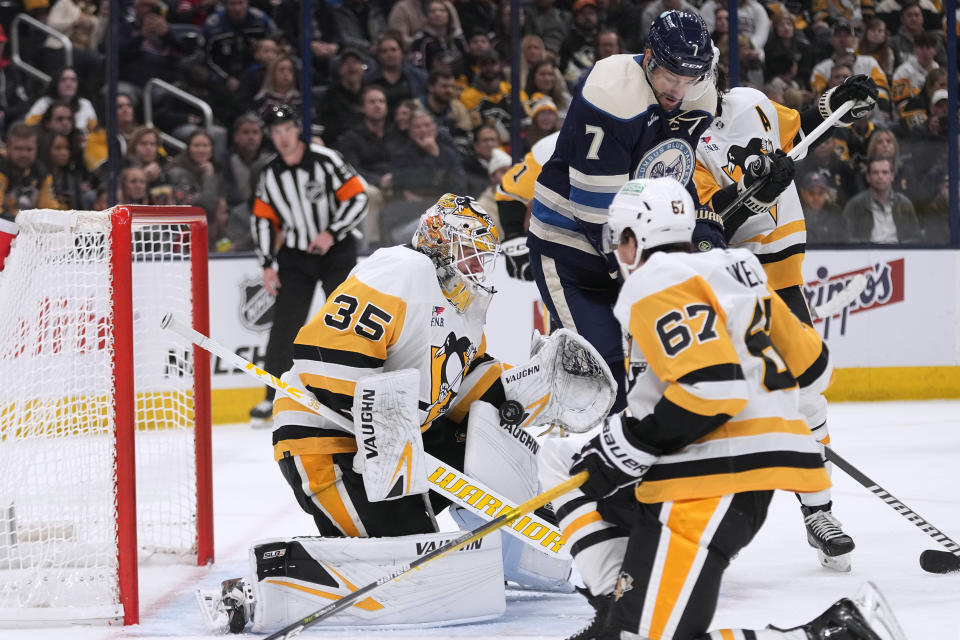 Pittsburgh Penguins goaltender Tristan Jarry (35) blocks a shot behind Columbus Blue Jackets center Sean Kuraly (7) and Penguins right wing Rickard Rakell (67) during the second period of an NHL hockey game Tuesday, Nov. 14, 2023, in Columbus, Ohio. (AP Photo/Sue Ogrocki)