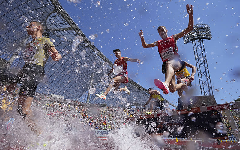 Runners compete in a men's 3,000 meters steeplechase heat