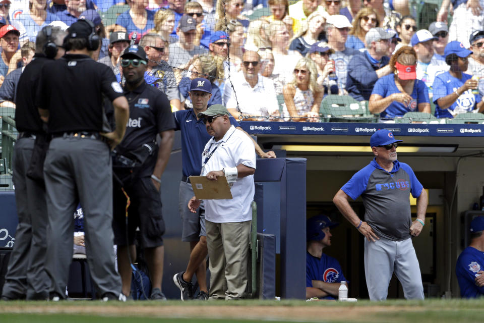 Chicago Cubs manager Joe Maddon, right, waits for a replay review during the sixth inning of a baseball game against the Milwaukee Brewers, Sunday, July 28, 2019, in Milwaukee. (AP Photo/Aaron Gash)