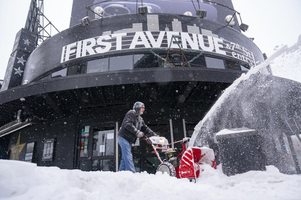 Bryan Erickson clears snow in front of First Avenue Thursday, Feb. 23, 2023 in Minneapolis. Dangerous winter weather is ravaging the nation from California through the northern Plains. (Alex Kormann/Star Tribune via AP)