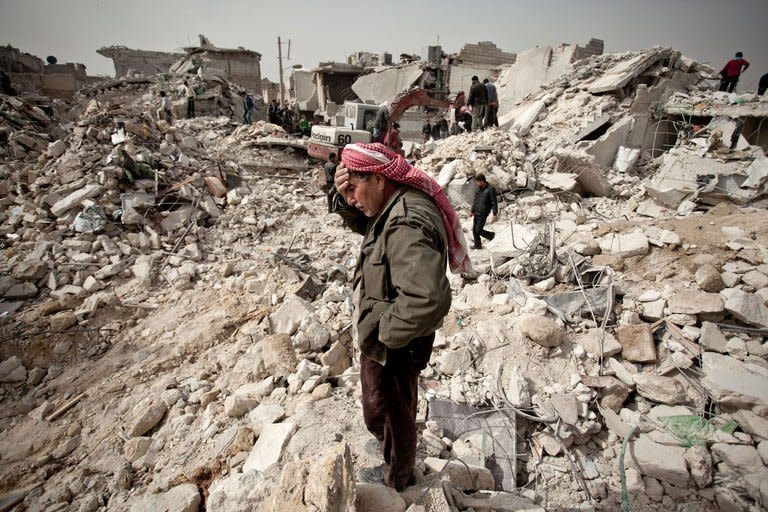 A Syrian man reacts while standing on the rubble of his house while others look for survivors and bodies in the Tariq al-Bab district of the northern city of Aleppo on February 23, 2013. Turkey and the United States lashed out against the Syrian regime after the death toll from a missile strike on Aleppo rose to 58, while a French photographer wounded in the conflict was confirmed dead