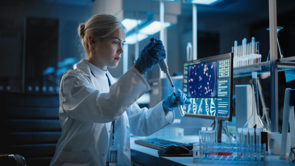 A scientist uses a pipette to work with medical samples.