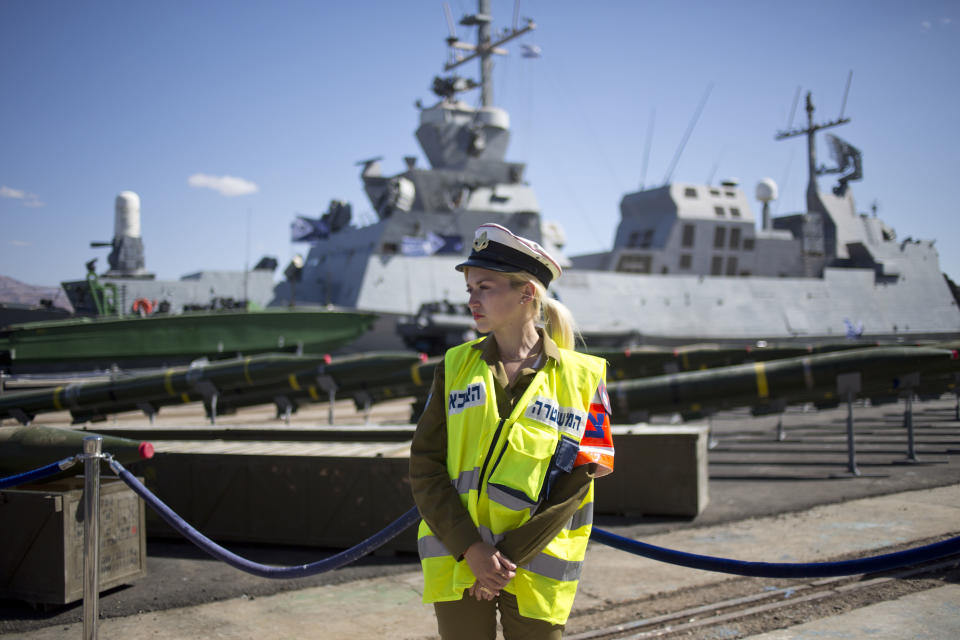 An Israeli military policewoman stands in front of a display of rockets seized from the Panama-flagged KLOS C civilian cargo ship that Israel intercepted last Wednesday, about 100 miles (160 kilometers) off the coast of Sudan, at a military port in the Red Sea city of Eilat, southern Israel, Monday, March 10, 2014. Israel has alleged the shipment was orchestrated by Iran and was intended for Islamic militants in Gaza, a claim denied by Iran and the rockets' purported recipients. Israel's military says the cargo ship carried 40 rockets with a range of up to 160 kilometers (100 miles) and dozens of mortar shells. (AP Photo/Ariel Schalit)