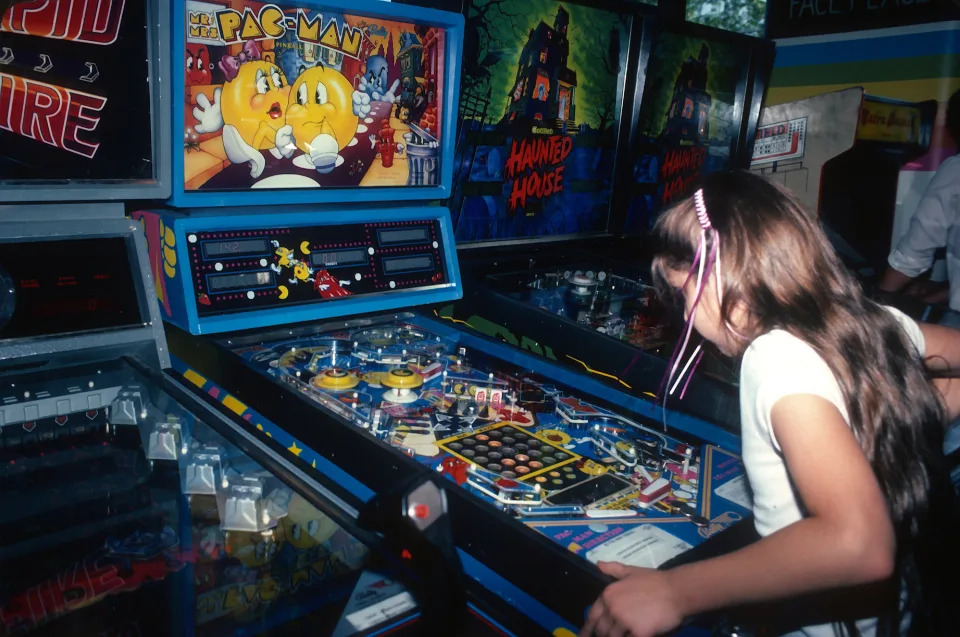 A young girl playsPac-Man at an arcade in Times Square circa 1982