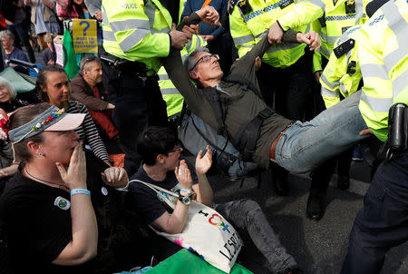 Police officers detain a climate change activist at Waterloo Bridge during the Extinction Rebellion protest in London, Britain April 18, 2019. REUTERS/Peter Nicholls