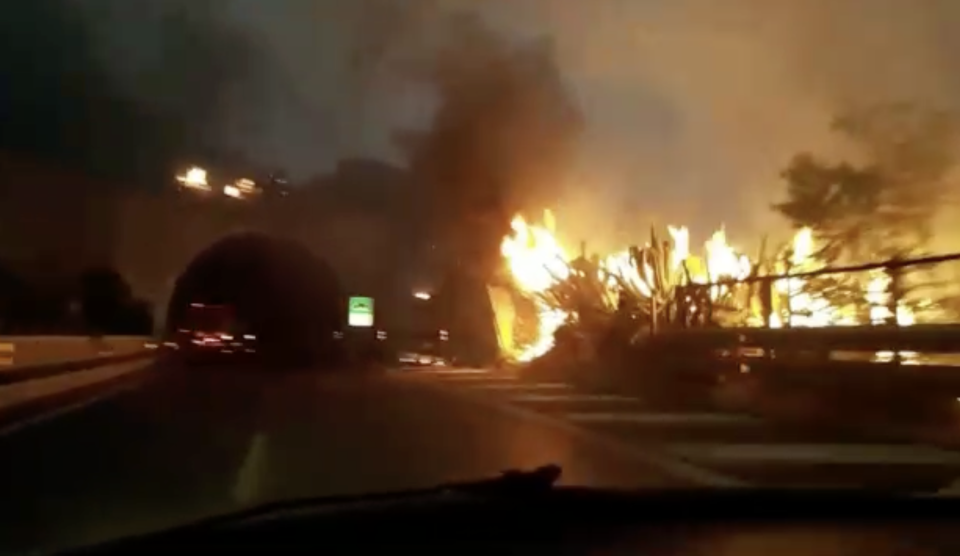 Flames approached cars on a highway in Palermo, Sicily, as wildfires raged. (Reuters)