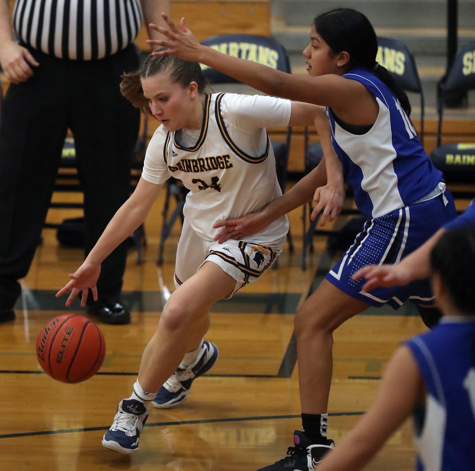 Bainbridge's Bella Ramirez (24) dribbles to the basket while under the pressure of North Mason's Briana Cuauhtenango (10) during their game on Tuesday, Jan. 31, 2023.