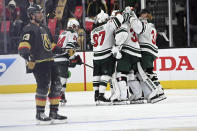 The Minnesota Wild celebrate their overtime victory over the Vegas Golden Knights in Game 1 of a first-round NHL hockey playoff series Sunday, May 16, 2021, in Las Vegas. (AP Photo/David Becker)