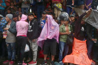 Honduran migrants, part of a caravan trying to reach the U.S., protect themselves from torrential rain during a new leg of their travel in Mazatenango, Guatemala October 18, 2018. REUTERS/Edgard Garrido