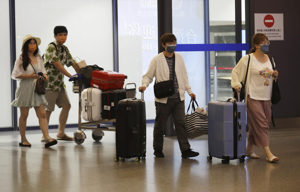 First group of foreign travelers arrive at Taoyuan International Airport in Taoyuan, Northern Taiwan, Thursday, Oct. 13, 2022. Taiwan announced that it will end mandatory COVID-19 quarantines for people arriving from overseas beginning Oct. 13. The Central Epidemic Command Center announced that the previous weeklong requirement will be replaced with a seven-day self-monitoring period. (AP Photo/Chiang Ying-ying)