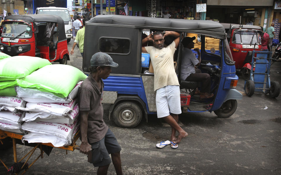 A Sri Lankan worker takes a break leaning against a three-wheeler in a whole sale market in Colombo, Sri Lanka, Tuesday, April 30, 2019. Sri Lanka is limping back to normalcy after the devastating bomb attacks on Easter Sunday that killed more than 250 people and wounded hundreds more. People and vehicles are slowly coming back on the road and shops are open but traders say that their business remain drastically low. (AP Photo/Manish Swarup)
