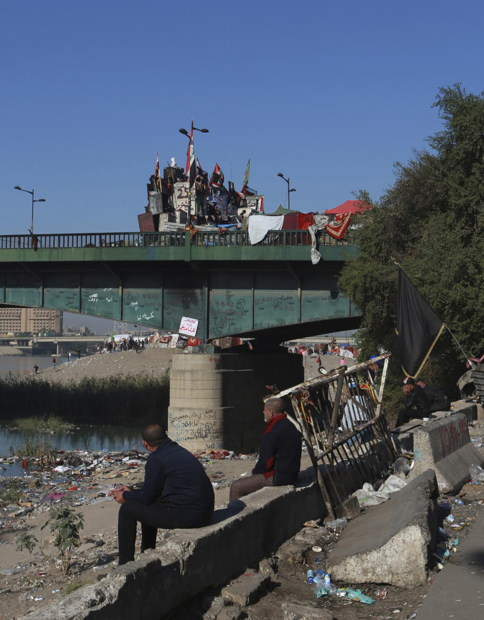 Anti-government protesters stage a sit-in on and around a bridge leading to the Green Zone government areas, during ongoing protests in Baghdad, Iraq, Thursday, Nov. 21, 2019. Iraqi officials say three anti-government protesters have been killed in clashes with security forces overnight in Baghdad. (AP Photo/Khalid Mohammed)