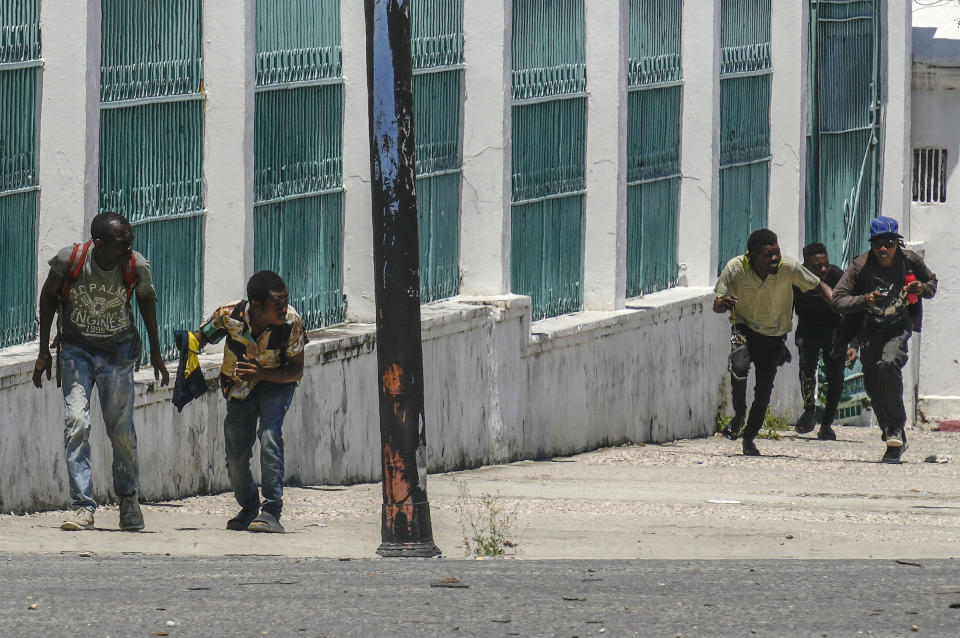 People run for cover as shots ring out near the National Palace, in Port-au-Prince, Haiti, April 30, 2024. (AP Photo/Ramon Espinosa)