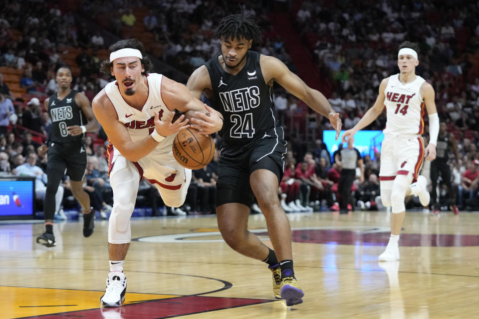 Brooklyn Nets guard Cam Thomas (24) and Miami Heat forward Jaime Jaquez Jr. (11) battle for a loose ball during the first half of an NBA basketball game, Wednesday, Nov. 1, 2023, in Miami. (AP Photo/Wilfredo Lee)