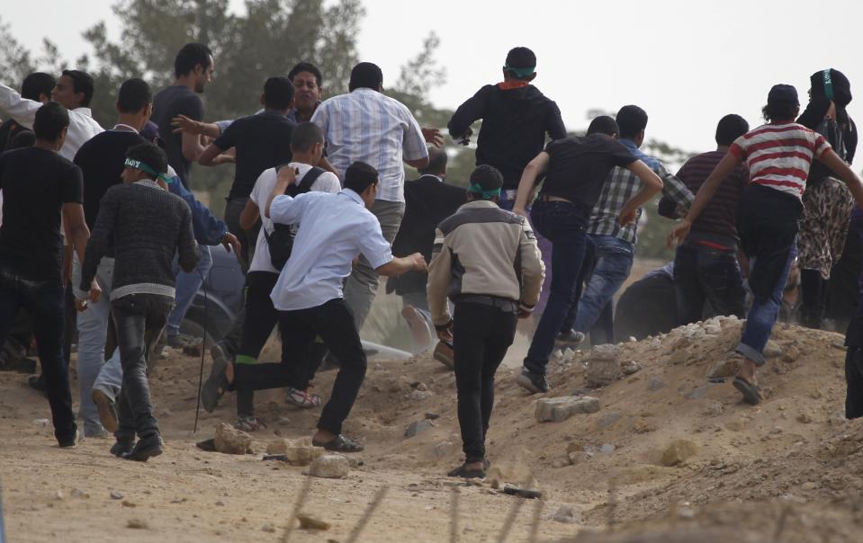 Supporters of the Muslim Brotherhood and ousted Egyptian President Mohamed Mursi chase after journalists in an attempt to get them to leave the area outside the police academy on the outskirts of Cairo