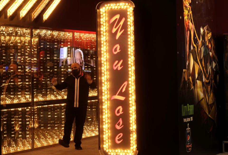 A man wearing a mask dances amid a brightly-lit display