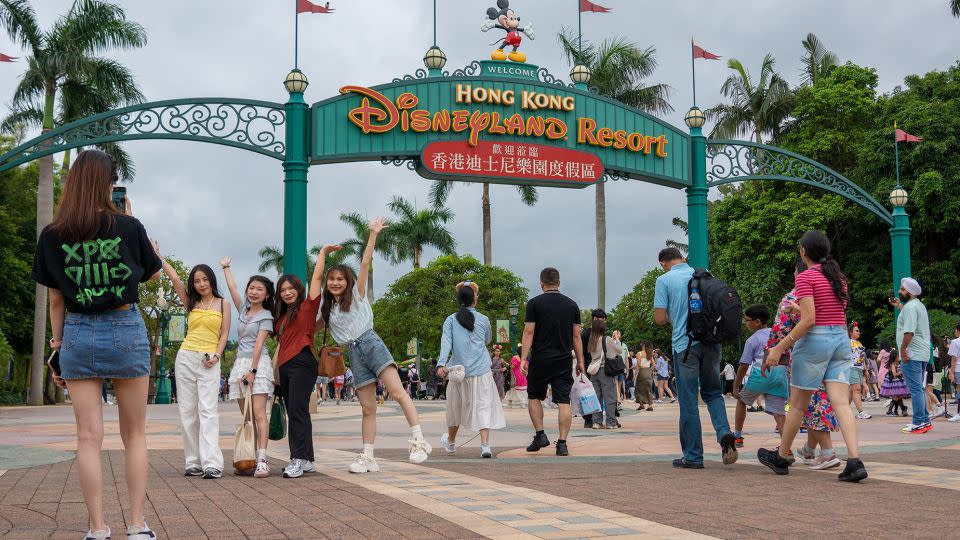 People pose for pictures at the entrance of Hong Kong Disneyland. - Noemi Cassanelli/CNN