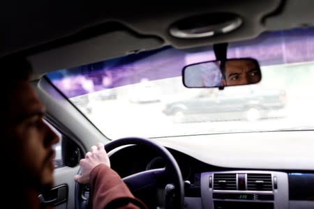 Venezuelan priest Luis Antonio Salazar drives a car toward a location to record a video for his social media in Caracas