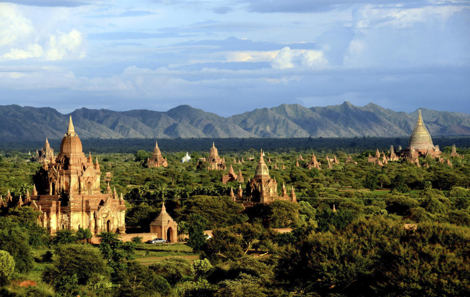 In this Aug. 15, 2013 photo, ancient temples stand in Bagan, central Myanmar. After closing its doors to the West for half a century, Myanmar has reopened, inviting all to come and discover its treasures, ancient palaces of kings long gone, legends and mysteries told in stone. With ill-equipped roads and railways, there is no better way to explore than by river. Public ferries crisscross through glistening green paddies; old teak fishing boats can be rented by the day. (AP Photo/Khin Maung Win)