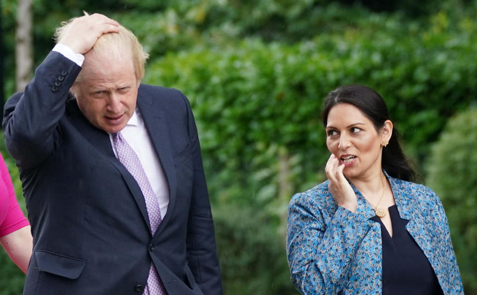 <p>Britain's Prime Minister Boris Johnson (L) and Britain's Home Secretary Priti Patel (R) visit to Surrey Police headquarters in Guildford, south west of London, on July 27, 2021 to coincide with the publication of the government's plans to tackle crime. (Photo by Yui Mok / POOL / AFP) (Photo by YUI MOK/POOL/AFP via Getty Images)</p>
