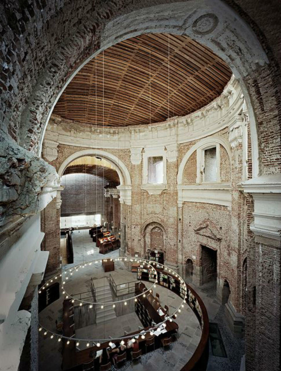 <p>A finales de los 90 y tras casi 50 años de abandono, el arquitecto J. I. Linazaroso convirtió la antigua iglesia de las Escuelas Pías de San Fernando, construida en el siglo XVIII y también conocida como la ermita del Pilar, en una biblioteca. Hoy es un centro asociado a la Universidad Nacional de Educación a Distancia. (Foto: Pinterest). </p>