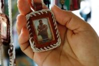 A woman holds an image of Mexican drug lord Joaquin "El Chapo" Guzman at a stall outside the "Saint Jesus Malverde" chapel in Culiacan