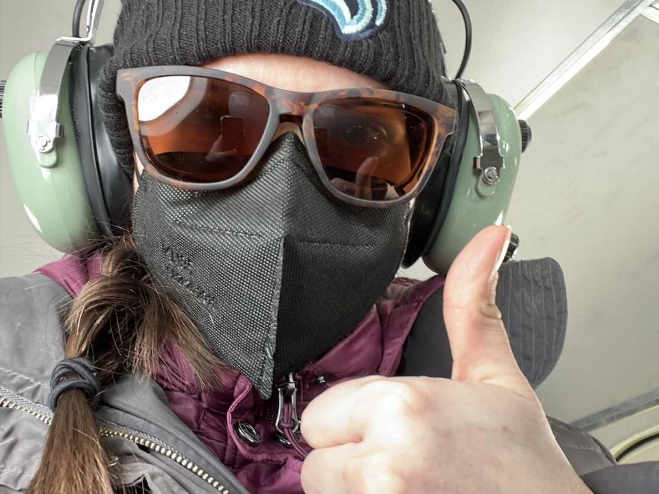 Abby wearing sunglasses and a mask, giving a thumbs up