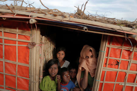 Rohingya refugees look from inside their shelter as food ration cards are distributed at the camp for widows and orphans inside the Balukhali camp near Cox's Bazar, Bangladesh, December 5, 2017. REUTERS/Damir Sagolj