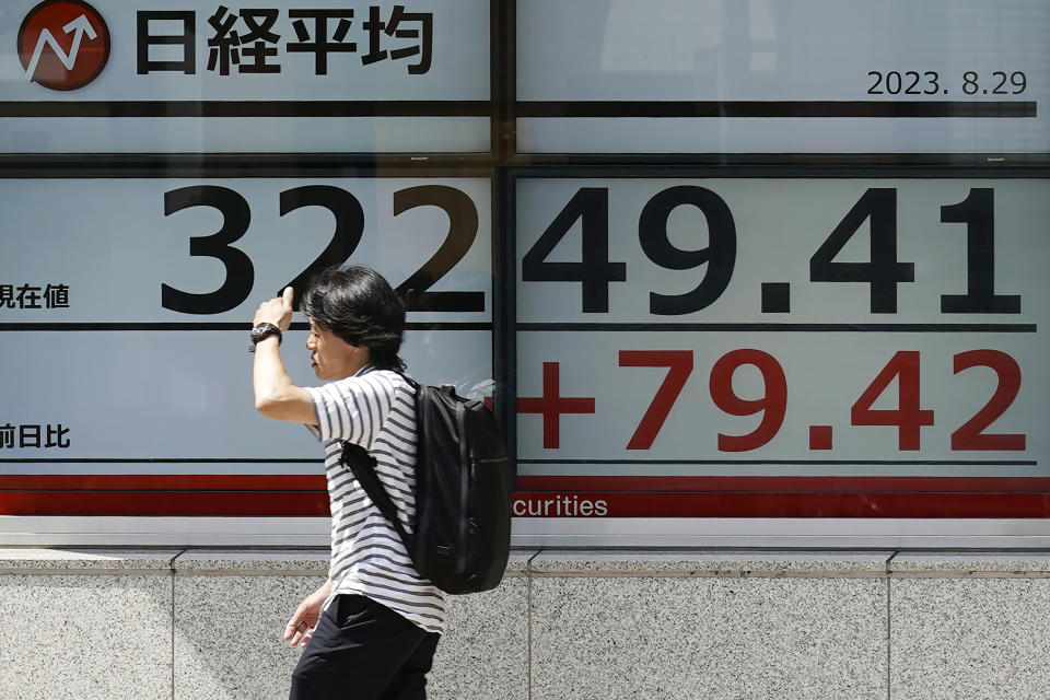 A person walks in front of an electronic stock board showing Japan's Nikkei 225 index at a securities firm Tuesday, Aug. 29, 2023, in Tokyo. Asian shares mostly rose Tuesday as markets shift their attention from the U.S. Federal Reserve to earnings and economic reports (AP Photo/Eugene Hoshiko)