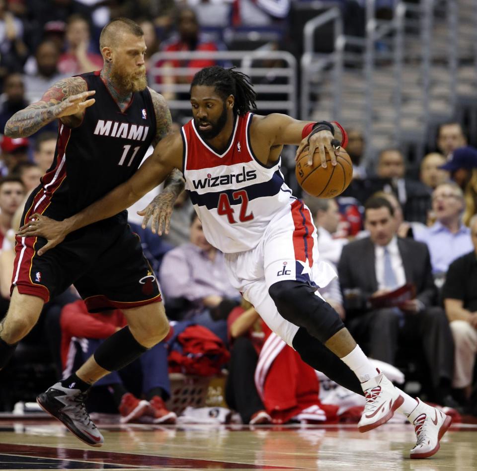 Washington Wizards forward Nene (42), from Brazil, drives against Miami Heat forward Chris Andersen (11) in the first half of an NBA basketball game, Monday, April 14, 2014, in Washington. (AP Photo/Alex Brandon)