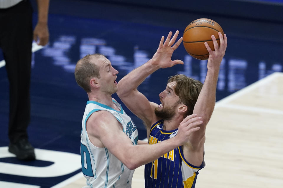 Indiana Pacers' Domantas Sabonis (11) goes to the basket against Charlotte Hornets' Cody Zeller (40) during the first half of an NBA basketball Eastern Conference play-in game Tuesday, May 18, 2021, in Indianapolis. (AP Photo/Darron Cummings)