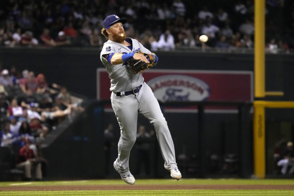 Los Angeles Dodgers third baseman Justin Turner makes an off-balance throw for the out on a ball hit by Arizona Diamondbacks' Nick Ahmed during the seventh inning of a baseball game Friday, July 30, 2021, in Phoenix. (AP Photo/Rick Scuteri)