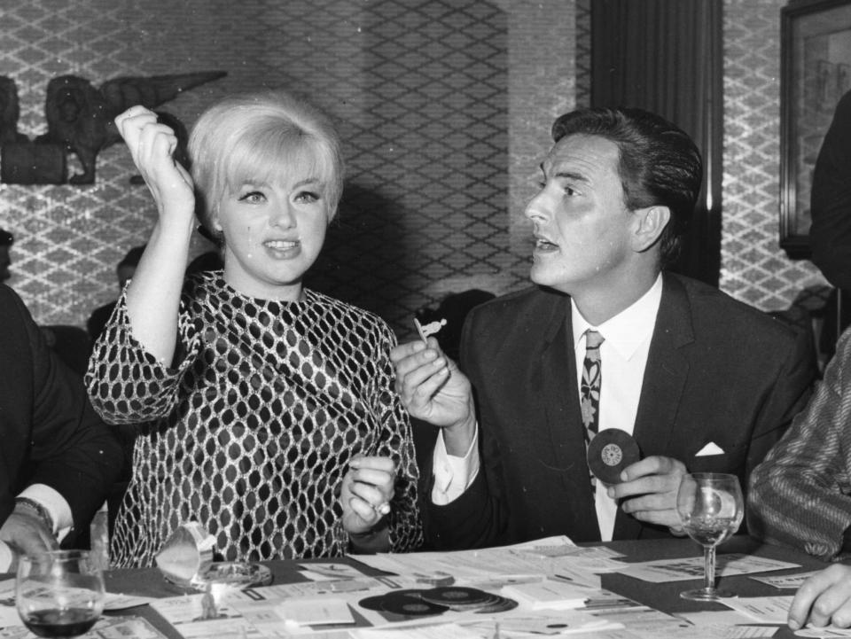 March 1967: English comedian Roy Jackson, with (from left) Diana Dors, Bob Monkhouse (1928 - 2003) and Honey Langtree, playing the board game he invented, 'Showbusiness Impresario'. (Photo by Ray Moreton/Keystone Features/Getty Images)