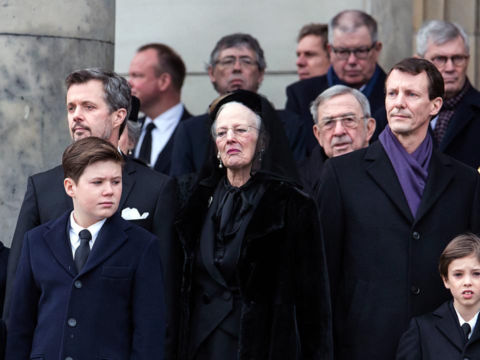 Queen Margrethe, Prince Frederik, and Prince Joachim stand as the coffin of Prince Henrik at his funeral.