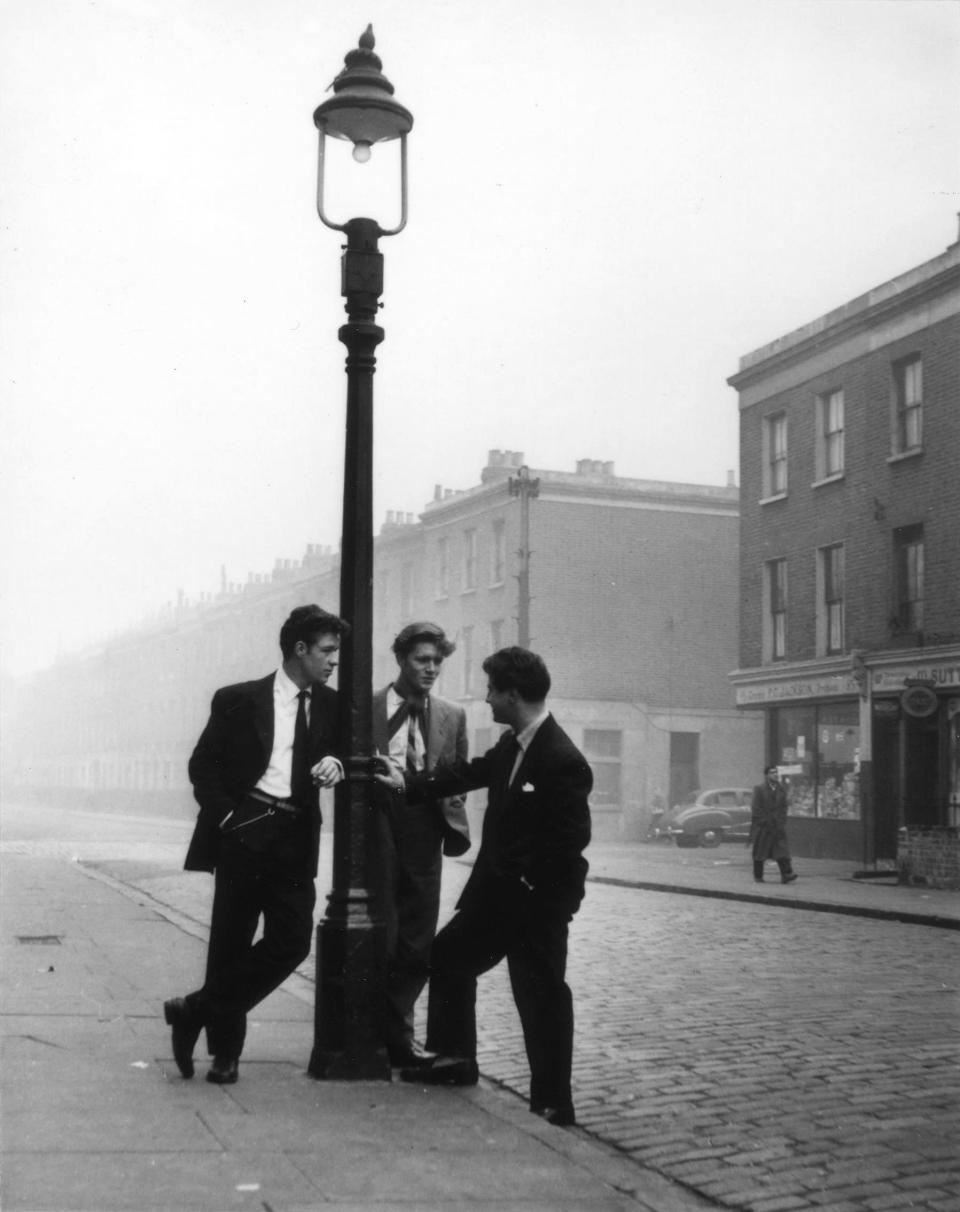 A group of men chat by a lamp post in 'Too Many Spivs', 1954. Hardy is best known for his work during the Second World War and in post-War Britain (Bert Hardy/ Getty Images)