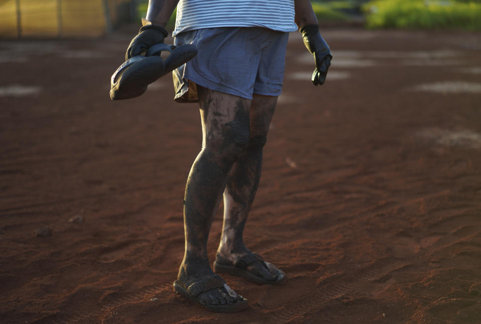 Sonia Topenio stands for a portrait, her legs covered in mud after working in the Hanapepe salt patch on Sunday, July 9, 2023, in Hanapepe, Hawaii. (AP Photo/Jessie Wardarski)