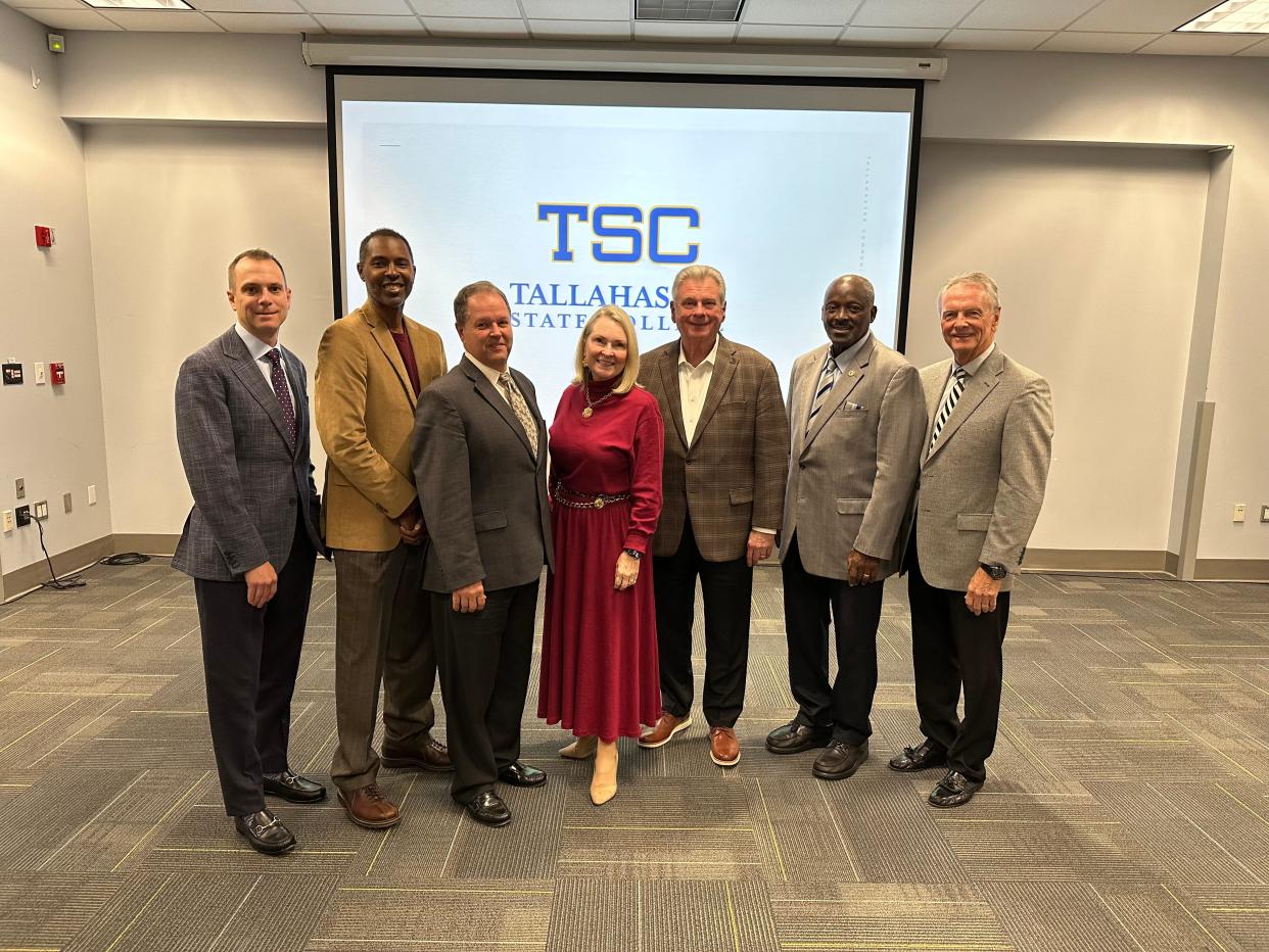TCC trustees and President Jim Murdaugh take a photo in front of a screen displaying the college's potential new name. (From left to right: Monte Stevens, Charlie Ward Jr., Jonathan Kilpatrick, Karen Moore, Jim Murdaugh, Eugene Lamb Jr., Frank Messersmith)
