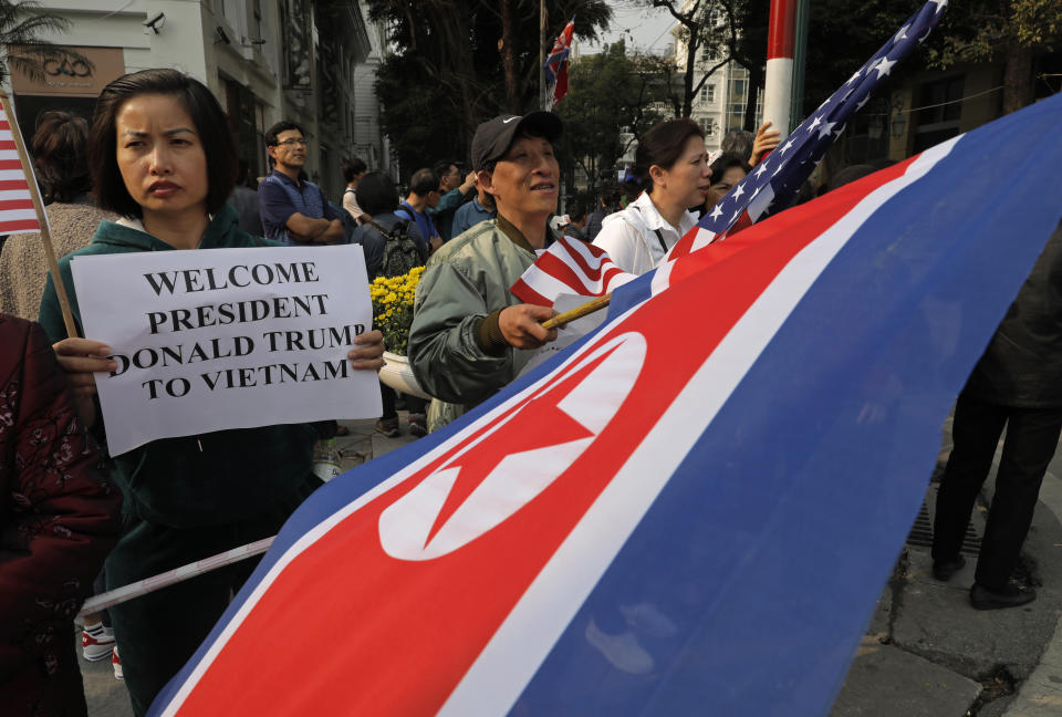 People hold placards and U.S. and North Korea flags outside the Metropole hotel where U.S. President Donald Trump and North Korean leader Kim Jong Un will have dinner in Hanoi, Vietnam, Wednesday, Feb. 27, 2019. The second summit between Trump and North Korean leader Kim Jong Un will take place in Hanoi on Feb. 27 and 28. (AP Photo/Vincent Yu)