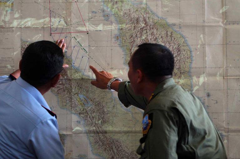 Indonesian Air Force officials at Medan city military base plot the Indonesian military search operation for the missing Malaysian Airlines flight MH370 on March 12, 2014