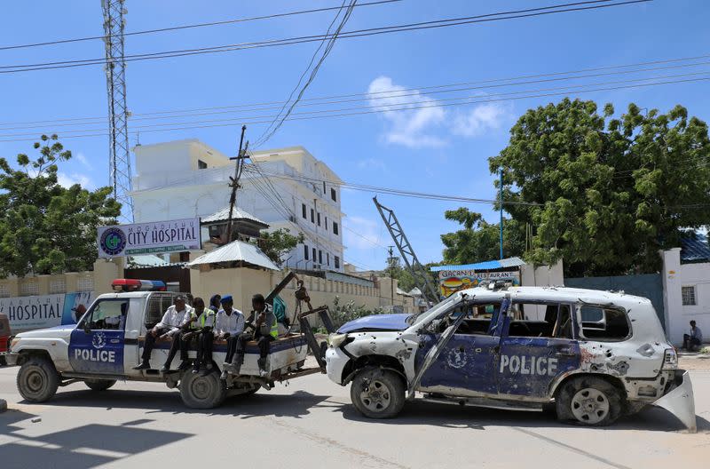 FILE PHOTO: Somali police officers tow their car from the scene of a roadside explosion in Hodan district of Mogadishu