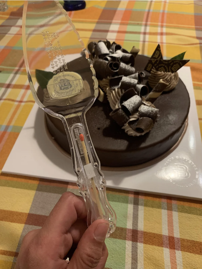 a person holding a cake cutter with a match on it