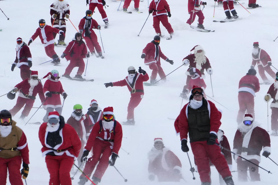 Some of the 300 skiers registered for the annual charity ski run descend the slopes at the Sunday River Ski Resort, Sunday, Dec. 11, 2022, in Newry, Maine. (AP Photo/Robert F. Bukaty)