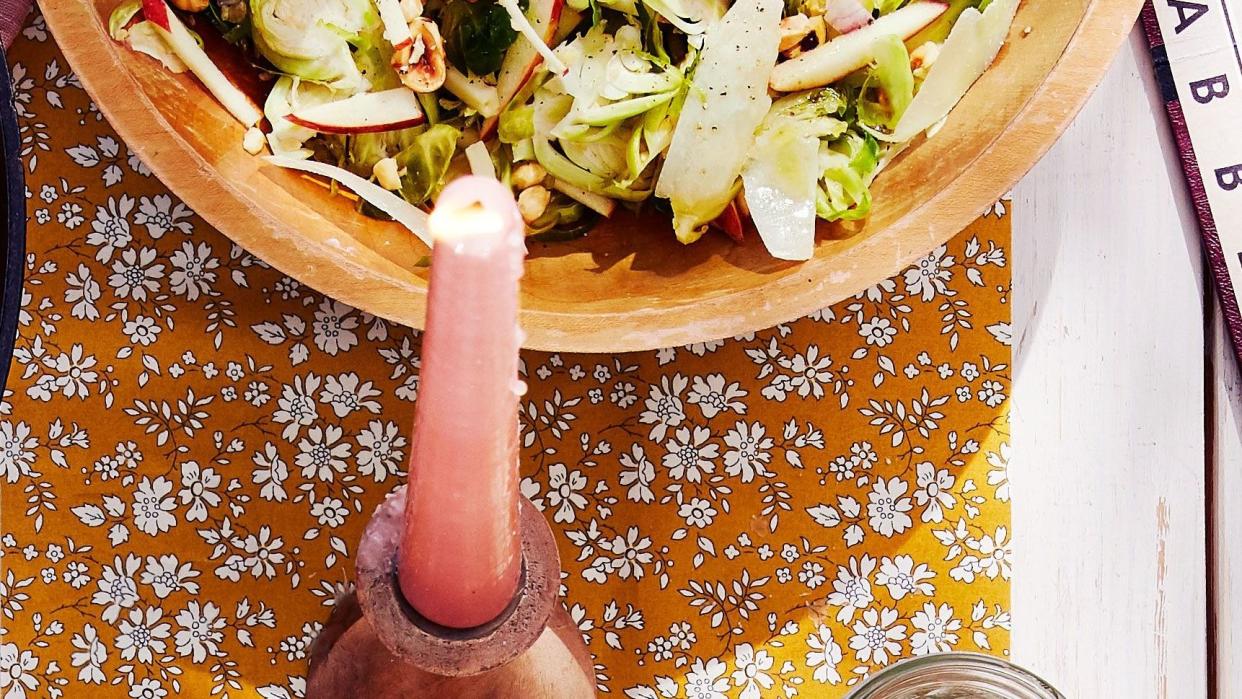 shaved brussels sprouts salad in a wooden bowl with silverware