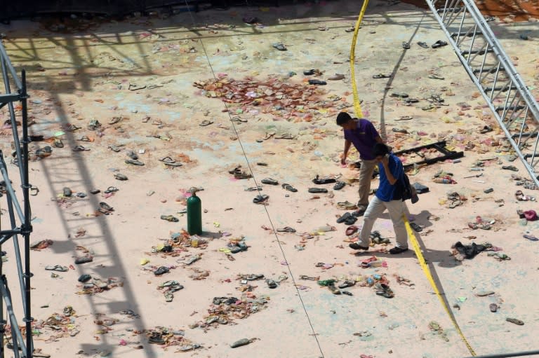 Two insurance investigators check the site of an explosion that injured hundreds of people at a water park in New Taipei City, on June 28, 2015