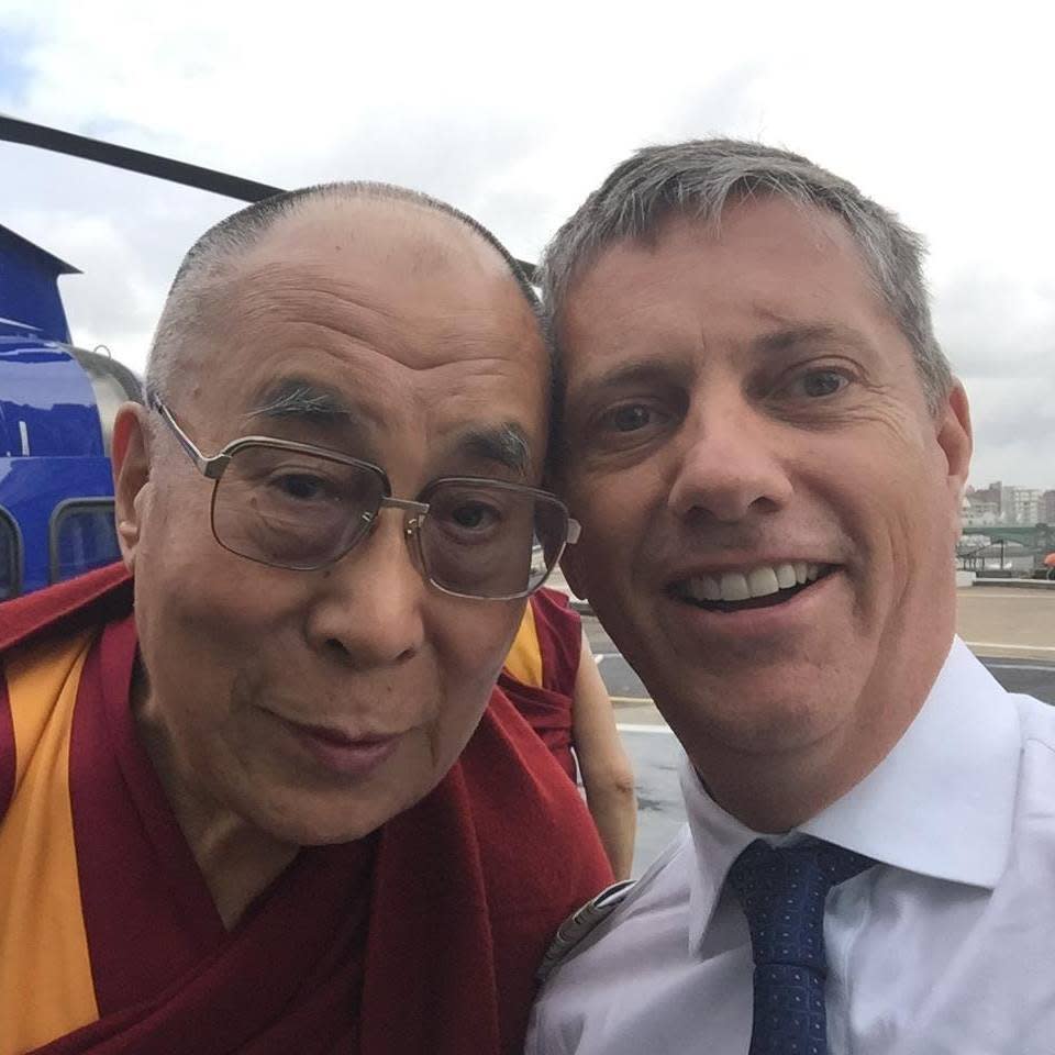 Eric Swaffer (right), pictured with the Dalai Lama, was piloting the helicopter when it crashed. (PA)