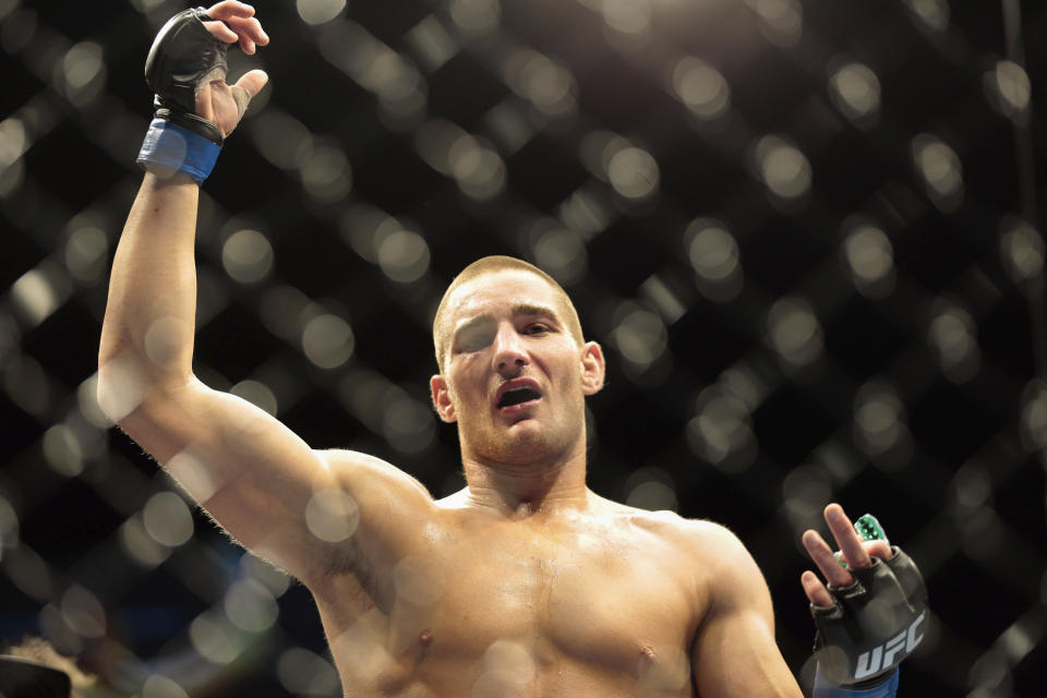 FILE - Sean Strickland from the United States shows his hands after he beats Luke Barnatt, left, from Great Britain in a middleweight fight during the UFC Fight Night mixed martial arts event in Berlin, on May 31, 2014. (AP Photo/Markus Schreiber, File)