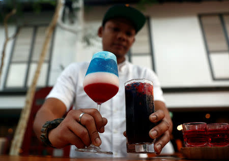 A bartender presents cocktails "Kim" and "Trump", special drinks offered at Escobar bar to mark the summit meeting between U.S. President Donald Trump and North Korean leader Kim Jong Un, in Singapore June 4, 2018. REUTERS/Edgar Su