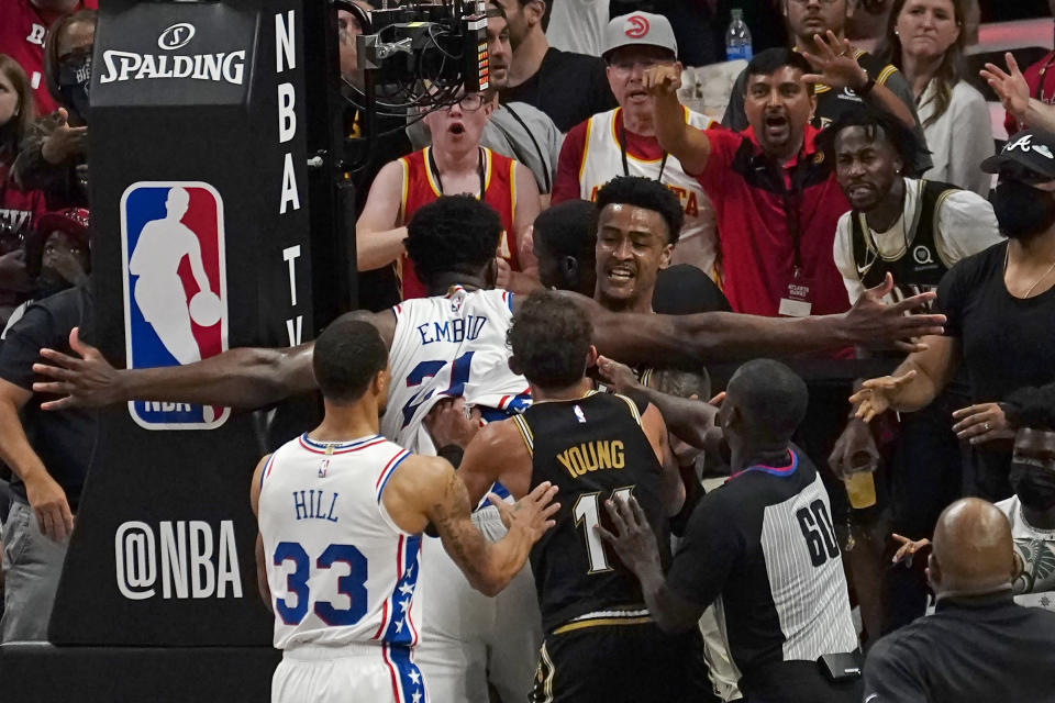 Philadelphia 76ers center Joel Embiid (21) and Atlanta Hawks forward John Collins (20) scuffle briefly during the second half of Game 6 of an NBA basketball Eastern Conference semifinal series Friday, June 18, 2021, in Atlanta. (AP Photo/John Bazemore)